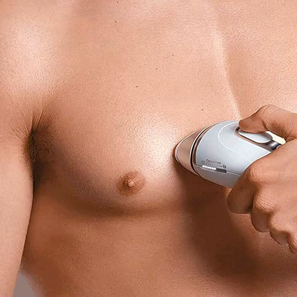 Homme épile torse avec épilateur lumière.